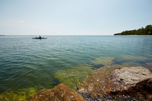 The lakefront with a kayaker in the distance.