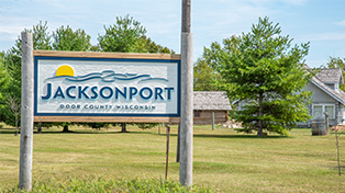 Jacksonport sign outside of building with tree