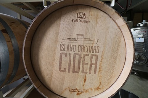 A rustic barrel imprinted with the Island Orchard logo at the cidery.