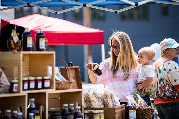 A woman and her baby at an outdoor farmers market