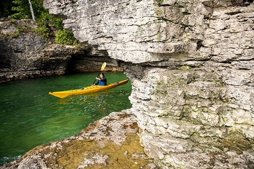 A kayaker paddling at Cave Point.