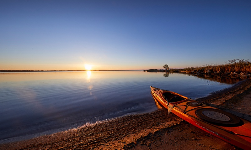 A kayak on a quiet sunrise beach