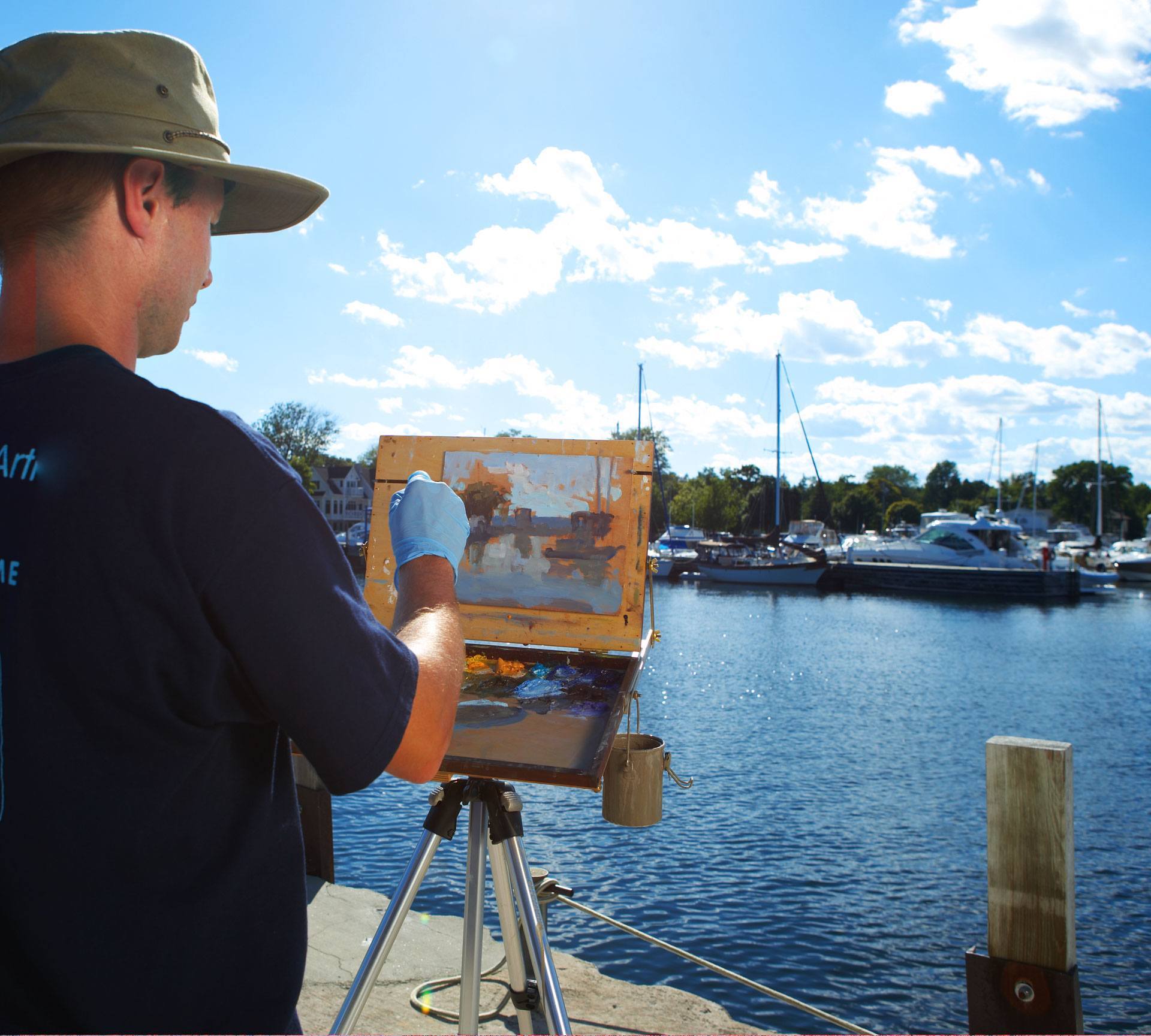 A man painting at the marina