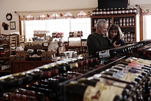 A couple looking at a wines in a wine shop.