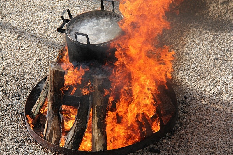 A fish boil basket on a fire.