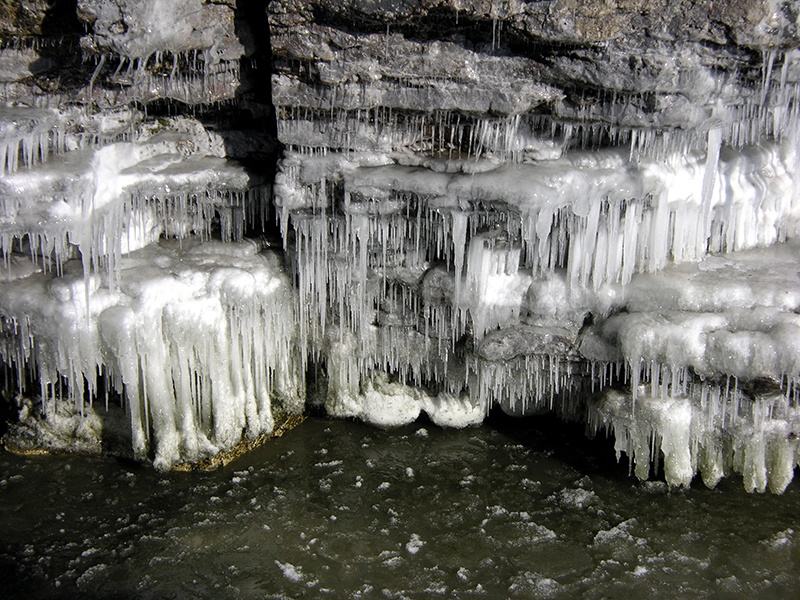 Icicles formed off cliff edges near water