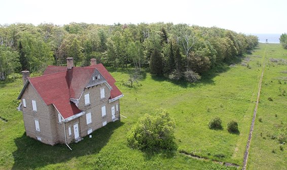 Large old house surrounded by trees.