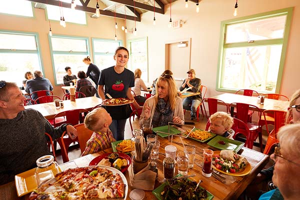 A family with kids dines on pizza at Wild Tomato.