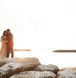 Couple embracing at the edge of the water.
