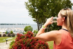 Woman drinking a glass of white wine looking out at the marina.