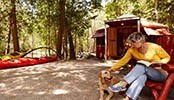 A woman and her dog sitting at a campsite