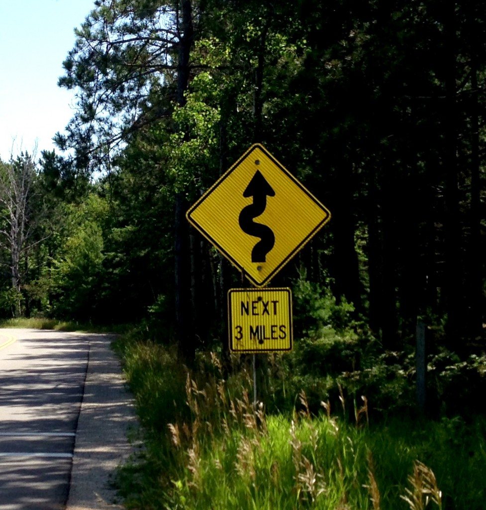 A sign showing a winding road ahead.