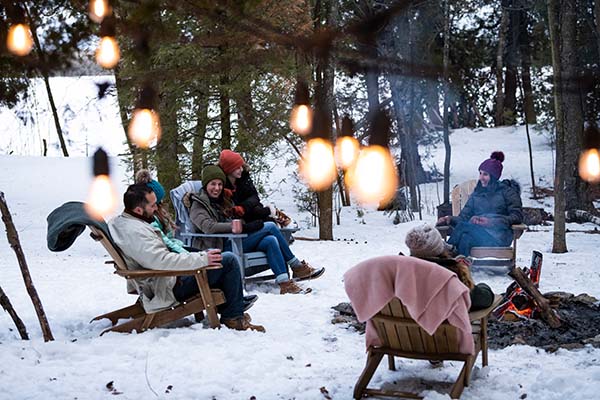 People bundled up and sitting in chairs together in the snow