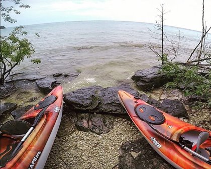 Two kayaks parked on the lakeshore.