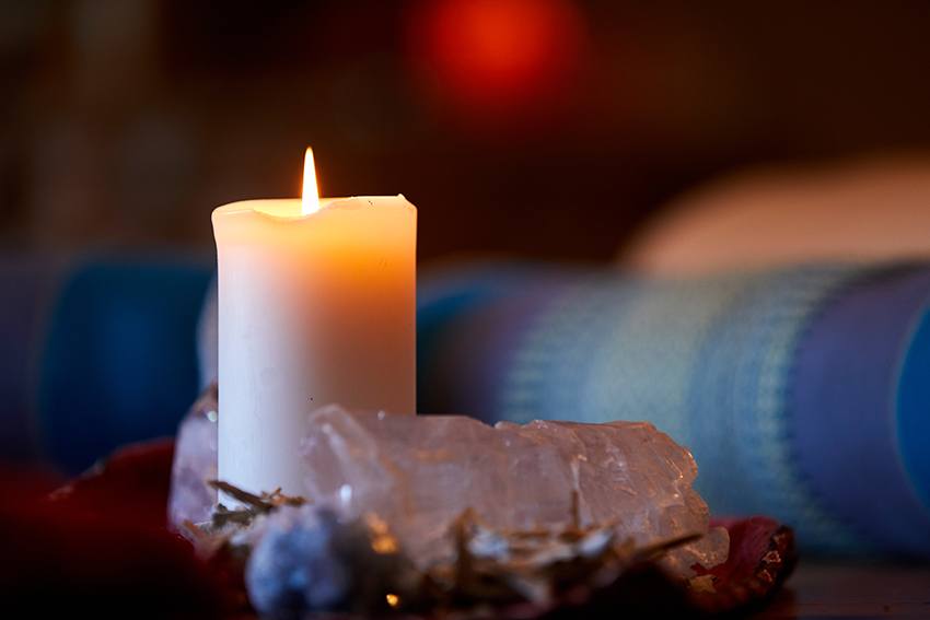 A lit candle and calming crystals