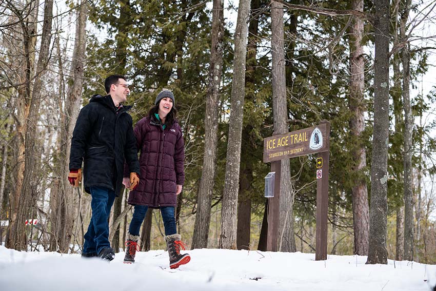 A couple walking in the snow along the Ice Age Trail