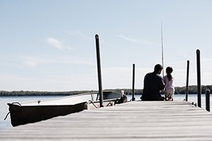 A father and daughter fishing off the end of a dock