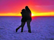 Silhouetted couple hugging in the snow.