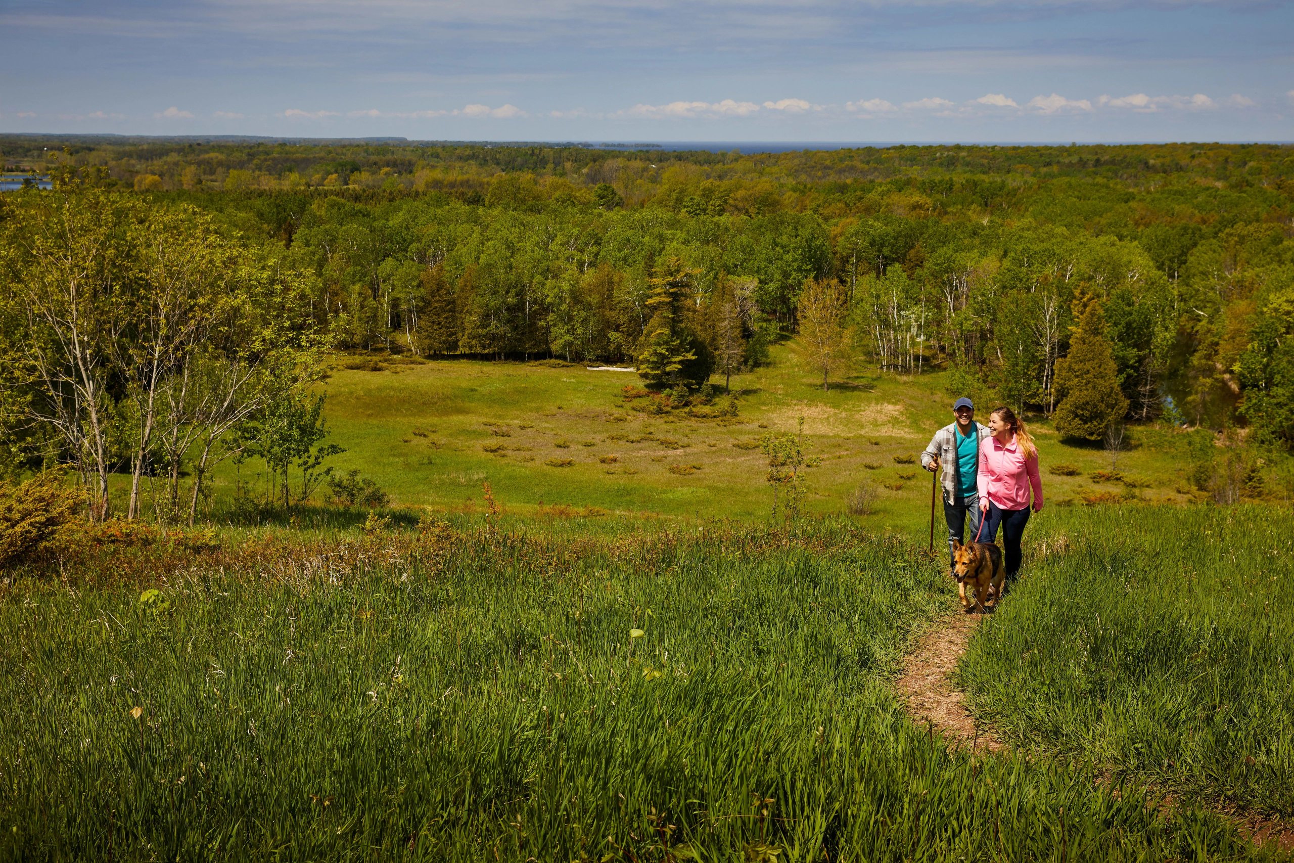 Door County Fall Camping Guide Couple and dog hiking in the meadow