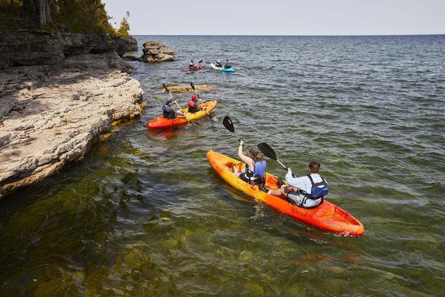 Door County: A Coveted Kayaking Destination A group kayaks along limestone bluffs and caves.