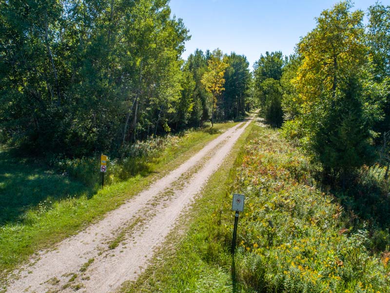 10 Hikes for Fall Adventure A view down the lush green and tree-lined Ahnapee Trail.