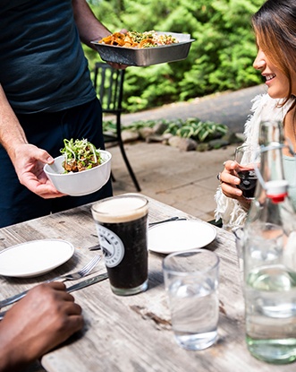 A waiter delivering food to a couple at their table