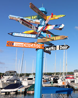Signs pointing in all directions on a signpost by a marina
