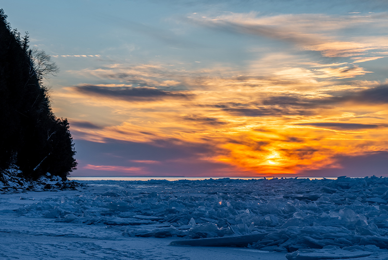 Winter Light: Why Door County Winter Sunsets are So Spectacular Sunset over an icy lake