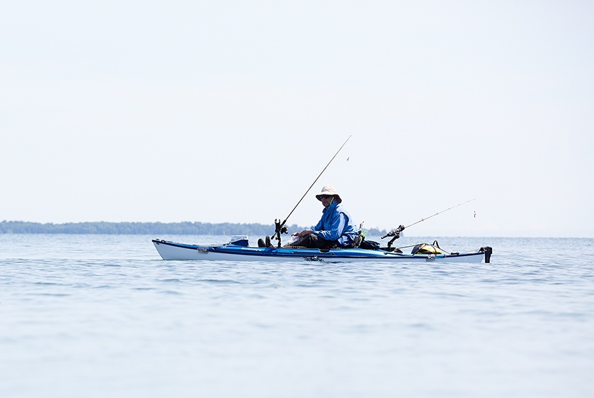 The Door County Fishing Guide A man fishes from a kayak on an inland lake