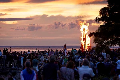 Community Spotlight: Ephraim A large fire burns at sunset as Fyr Bal revelers look on.