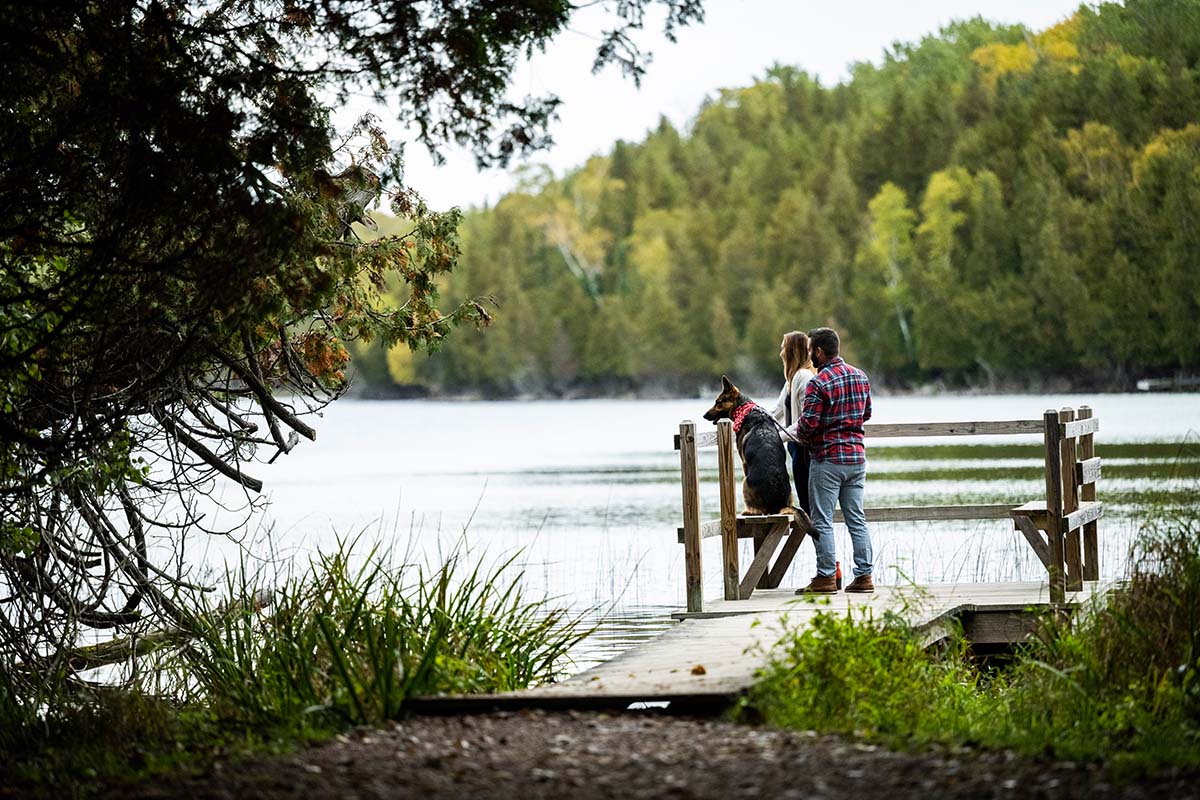 Lakes & Waterways Photo Tour A couple and their dog looks out at Little Lake from a peaceful dock.