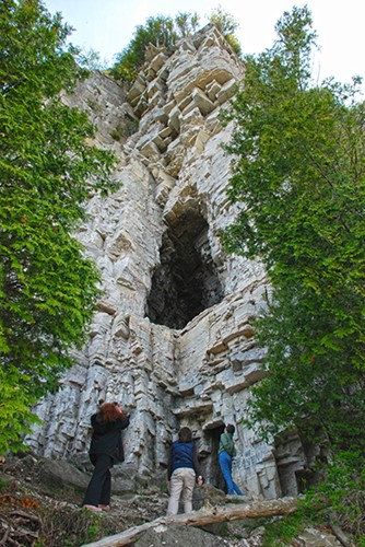6 Great Door County Hikes A view up a jagged cliffside with caves on Eagle Trail.