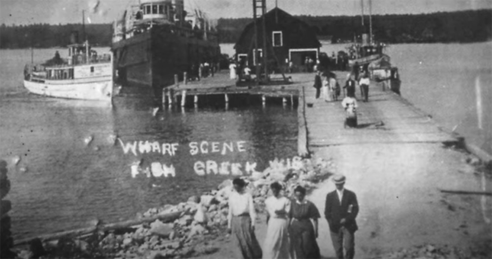 The Early Days of Tourism in Door County Vintage photo of early residents in front a dock and passenger boats