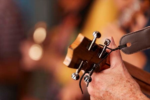 Community Spotlight: Washington Island A man's hands play ukelele at an open mic night.