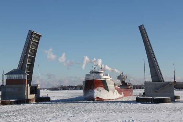 The Winter Fleet in Sturgeon Bay A winter freighter moves through the ice, heading toward land.