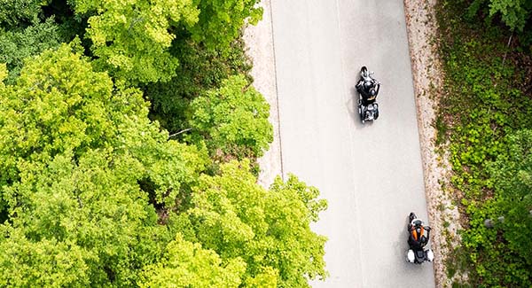 Aerial view of motorcycles on a tree-lined road