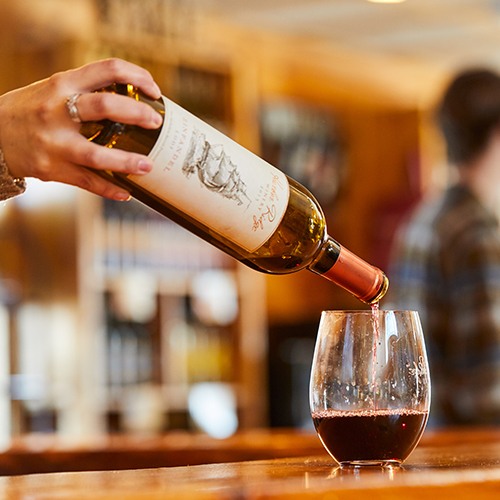 72-Hour Romantic Winter Getaway A bartender pours red wine into a stemless glass.