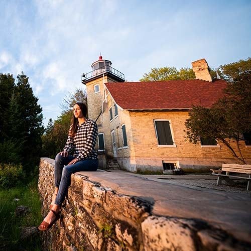 Fish Creek A woman sitting on a wall ledge by a building