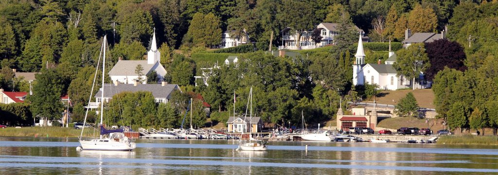 3-Day Spiritual Journey Sailboats in front of a town on the lake.