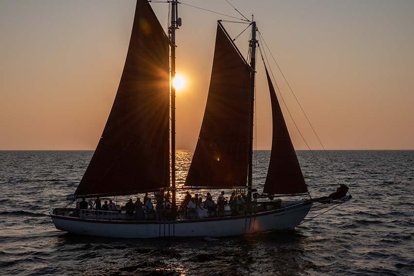 A sailboat on the water at sunset