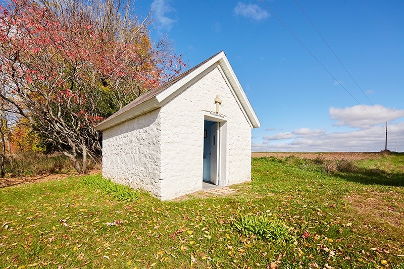 Architecture & Landmarks Small white stone chapel in a clearing.