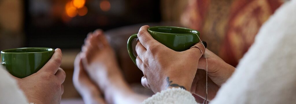 Closeup of people in robes with their feet up drinking tea