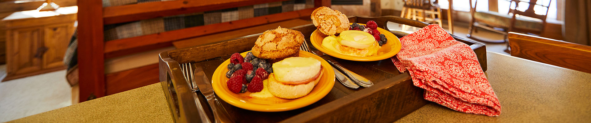 Bed & Breakfasts A couple chats in bed with a beautiful breakfast spread laid out before them on a tray.