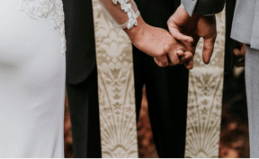 Weddings Closeup of bride and groom holding hands.