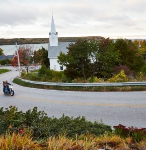 Weddings A white church with a steeple in the distance beyond a road.
