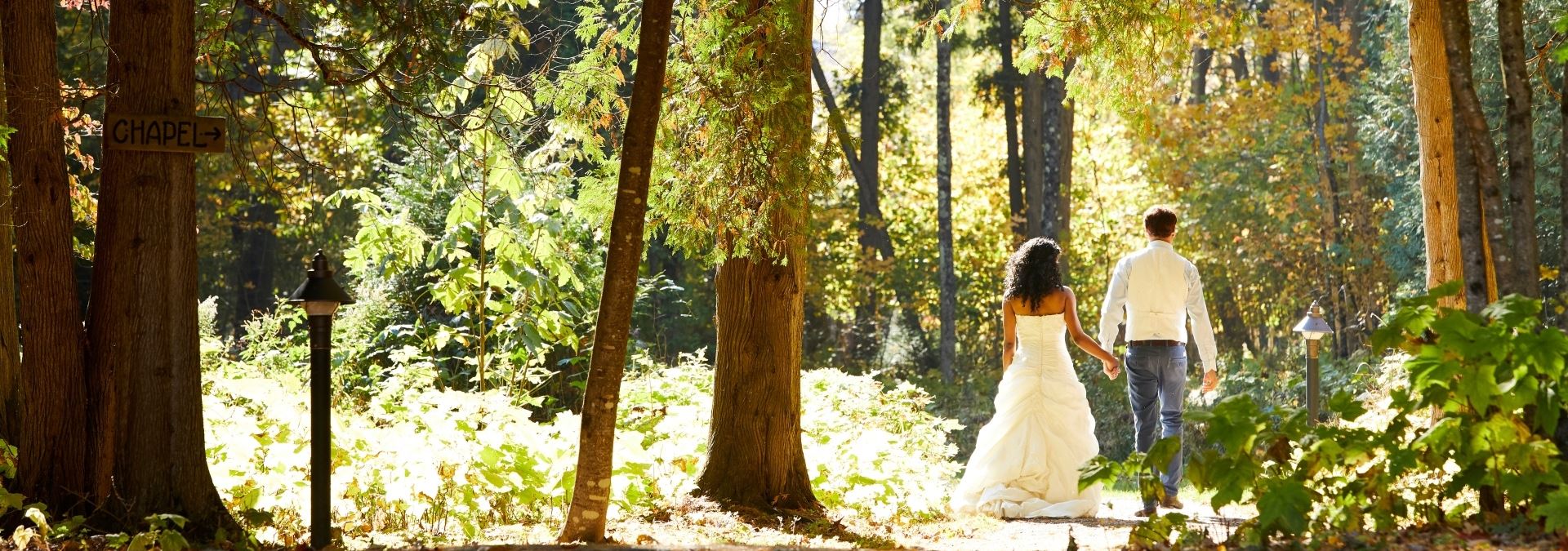 Weddings Bride and groom walking down a path through the woods