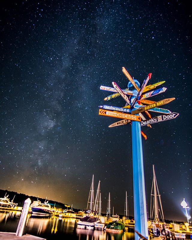 Sign post with many signs against a starry night sky