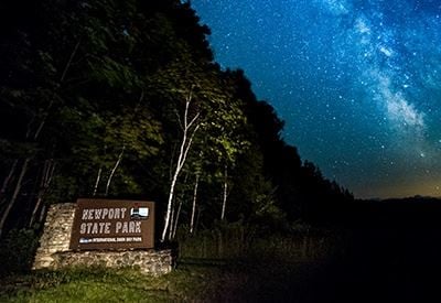 Northern Lights in Door County Newport state park with the Milky Way in the background.